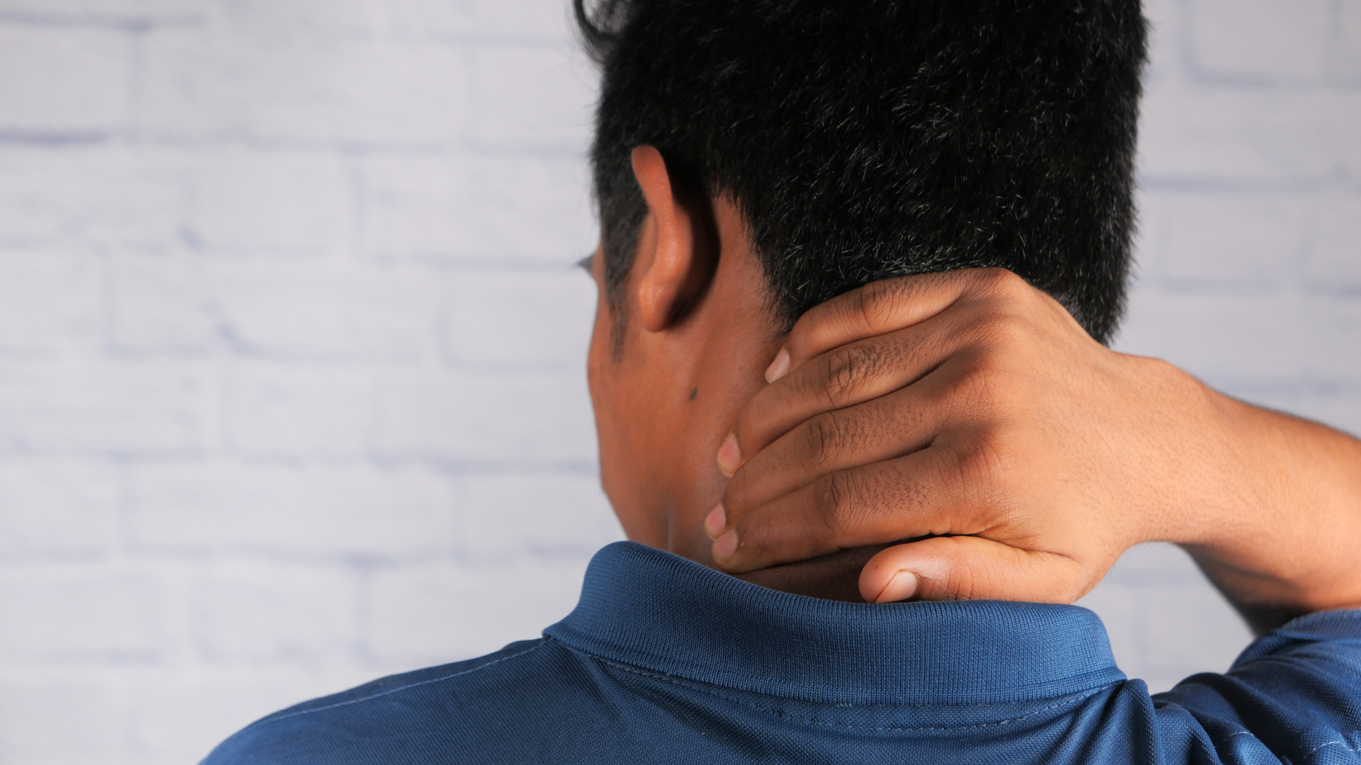 Um homem sentindo dor na cervical